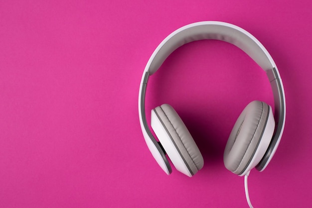 Foto de vista aérea superior de auriculares aislados sobre fondo rosa con copyspace