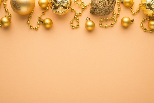 Foto de vista superior de bolas de árbol de navidad doradas y guirnalda de barba sobre fondo beige aislado con espacio vacío