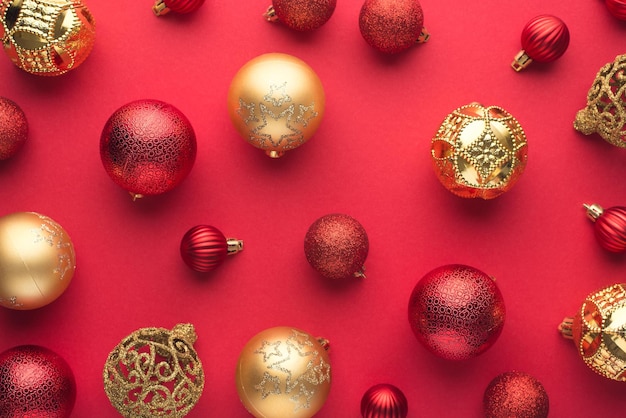 Foto de vista superior de bolas de árbol de Navidad rojas y doradas sobre fondo rojo aislado
