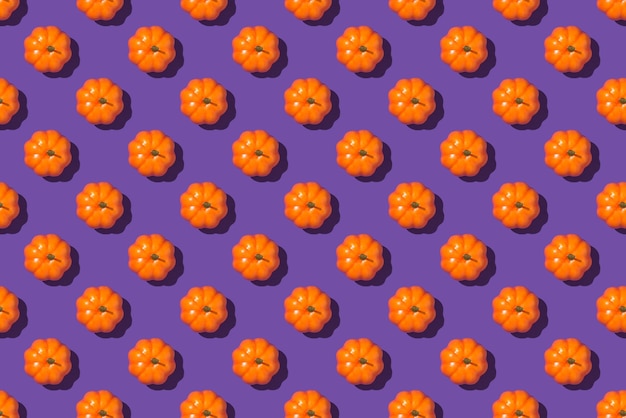 Foto de vista superior de calabazas naranjas sobre fondo violeta aislado