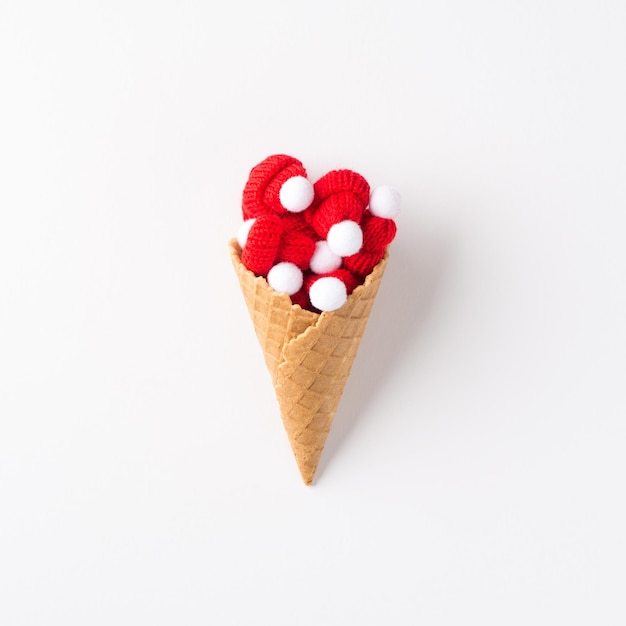 Foto de la vista superior del cono de helado con pequeños sombreros bobble sobre fondo blanco aislado