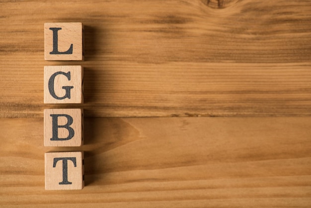 Foto de vista superior de cubos de madera etiquetados LGBT sobre fondo de madera aislado con espacio de copia