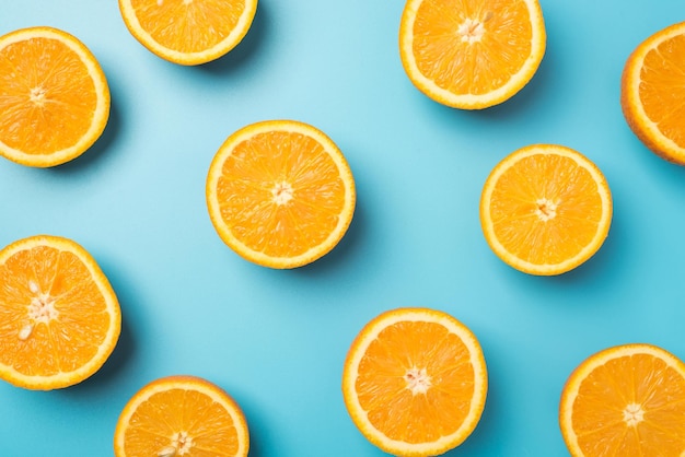 Foto de vista superior de jugosas rodajas de naranja sobre fondo azul claro aislado