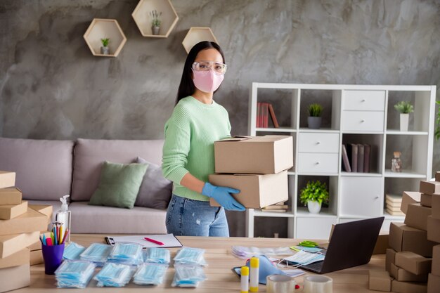 Foto von asiatischen Damengeschäften organisierte Bestellungen von Gesichtsgrippe-Erkältungsmasken weltweit verbreitet Tausende zufriedene Kunden, die Packungen für die Lieferung von Trageboxen nach dem Home-Office im Innenbereich vorbereiten