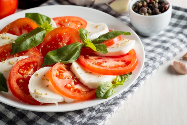 Foto von Caprese-Salat mit Tomaten, Basilikum, Mozzarella, Oliven und Olivenöl