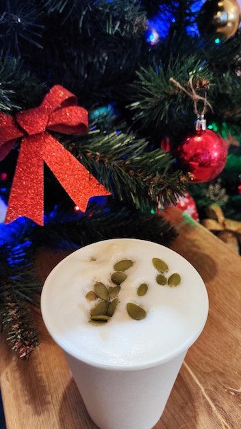 Foto von einem Glas Kaffee unter dem Weihnachtsbaum