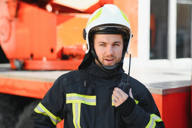 Foto von Feuerwehrmann mit Gasmaske und Helm in der Nähe von Feuerwehrauto