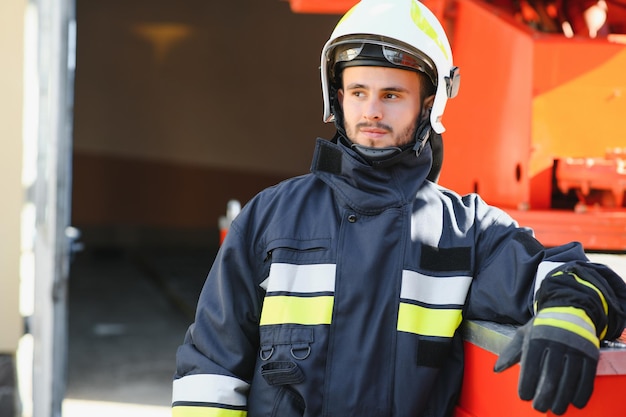 Foto von Feuerwehrmann mit Gasmaske und Helm in der Nähe von Feuerwehrauto