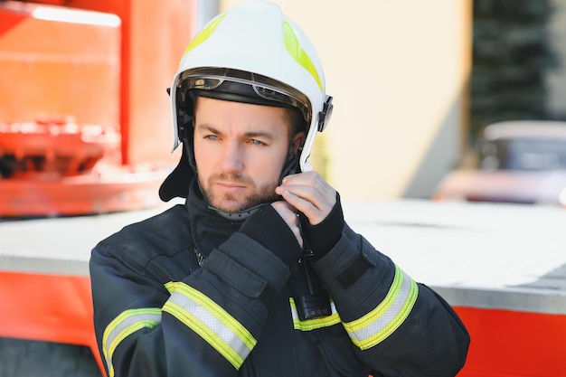 Foto foto von feuerwehrmann mit gasmaske und helm in der nähe von feuerwehrauto