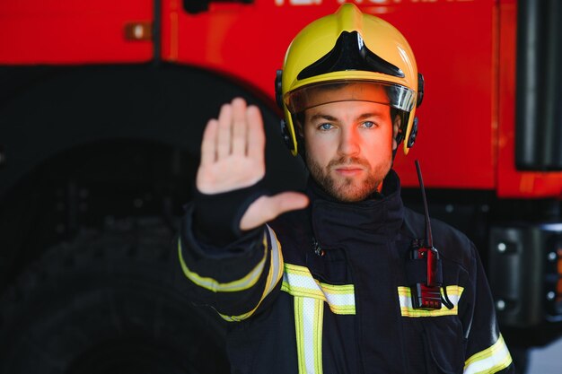 Foto foto von feuerwehrmann mit gasmaske und helm in der nähe von feuerwehrauto