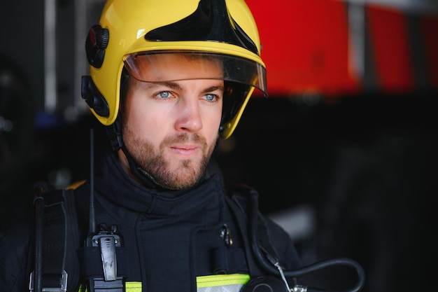 Foto von Feuerwehrmann mit Gasmaske und Helm in der Nähe von Feuerwehrauto