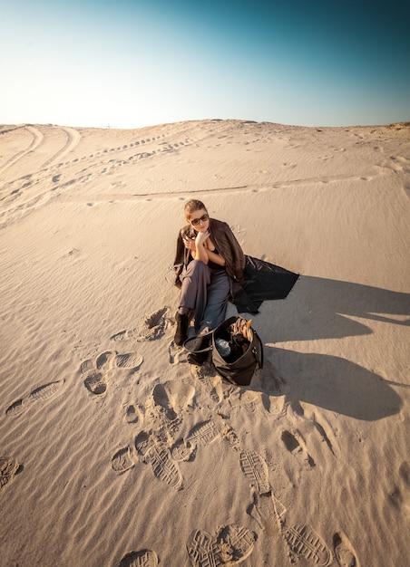 Foto von Frau mit Tasche in der Wüste verloren