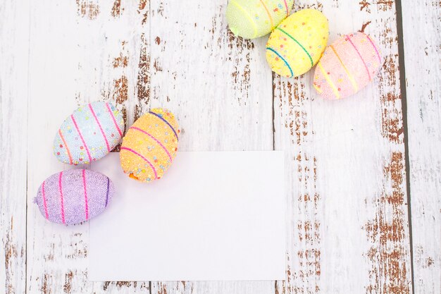 Foto von gemalten gekochten Eiern für Ostern auf einem weißen Holz mit Platz für Text.