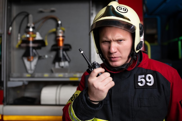 Foto von Mann Feuerwehrmann mit Helm im Radio sprechen