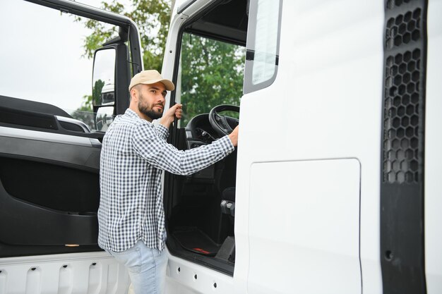 Foto foto von motiviertem lkw-fahrer, der in sein halb-lkw-langfahrzeug steigt