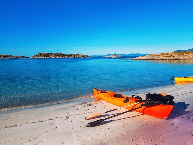 Foto von norwegen mit orangefarbenem boot des bewölkten himmels des meeres im sommer