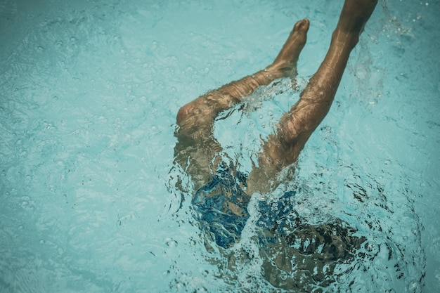 Foto von oben abstrakter Lebenshintergrund Nicht erkennbarer Kinderkörper Beine Füße Knie unter Wasser im Pool tief schwimmen tauchen weg Konzept der schwerelosen ungewissen Zukunft Kindheitsproblem Sportübungen