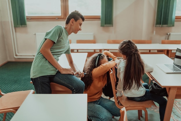 Foto von oben einer Gruppe von Schulkindern, die während einer Klasse im Klassenzimmer mit ihrem Lehrer auf einem Laptop lernen Selektiver Fokus Foto in hoher Qualität