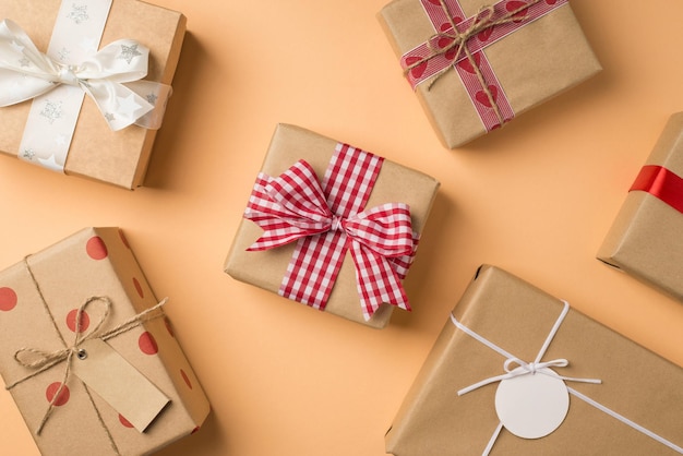 Foto von oben mit Dekorationen zum Valentinstag Viele Geschenkboxen aus Bastelpapier mit Schleifen und Schleifen auf isoliertem beigem Hintergrund