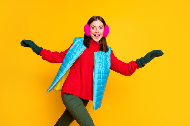 Foto von positivem fröhlichem Mädchen, das nach Winterherbst Schwarzer Freitag-Schnäppchen läuft, tragen Sie blaue rosa Pulloverhosen einzeln auf hell glänzendem Hintergrund