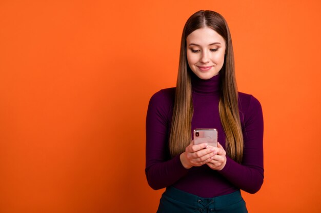Foto von positiven Mädchen Instagram Blogger verwenden Smartphone lesen soziale Netzwerknachrichten abonnieren tragen violette lila Pullover einzeln auf hell glänzendem Hintergrund