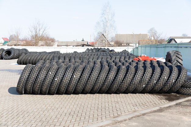 Foto von schwarzen großen Reifen auf Rädern für große Autos, die auf grauem Asphalt auf der Straße liegen.