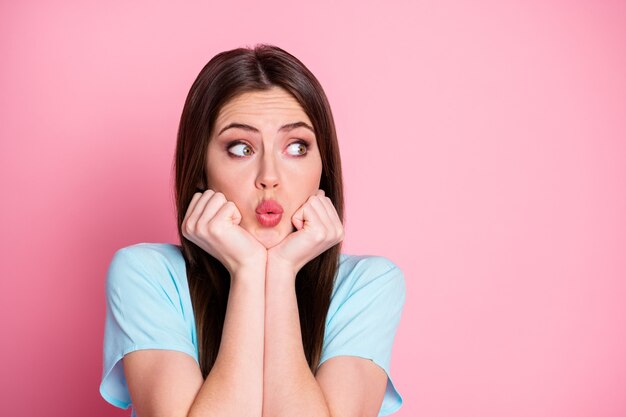 Foto von verängstigten Frauenarmen auf Kinnseite leerer Raum tragen lässiges blaues T-Shirt isoliert rosa pastellfarbenem Hintergrund