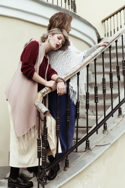 Foto von zwei schönen Frauen, die auf einer Treppe posieren