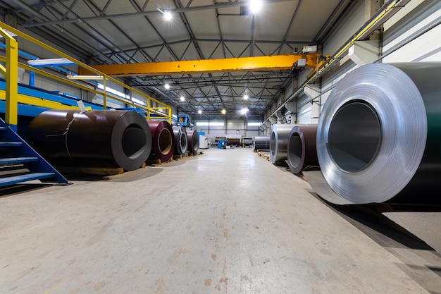 Fotoaufnahme einer Rolle aus lackiertem verzinktem Stahlblech an einer Schneidemaschine, Eisenhütten und Metallarbeiten in der Fabrik. Anlagenkonzept