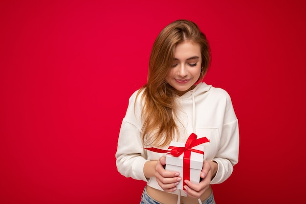 Fotoaufnahme einer ziemlich positiv überraschten jungen dunkelblonden Frau, die über buntem Hintergrund isoliert ist