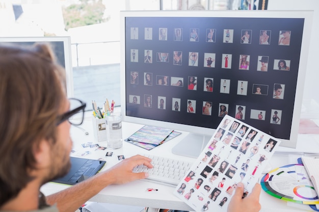 Foto fotoeditor, der an dem kontaktblatt arbeitet