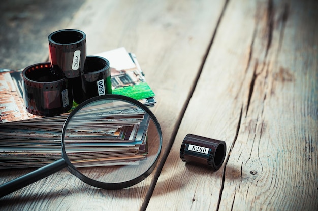 Fotofilmrollen Stapel Fotos und Lupe auf dem Schreibtisch