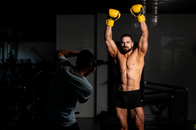 Fotograf aufgenommenes Foto eines Mannes in gelben Boxhandschuhen beim Boxen im Fitnessstudio