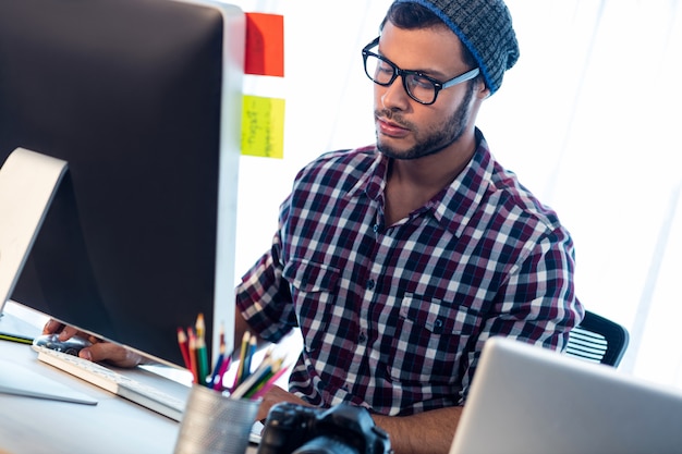 Fotograf, der am Computertisch arbeitet