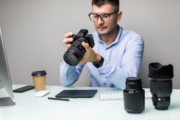 Fotograf, der Fotos von seiner Kamera auf den Computer im Büro hochlädt