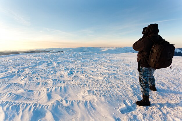 Fotograf des jungen Mannes in der Winterkleidung stehend und Foto im Sonnenlicht machend