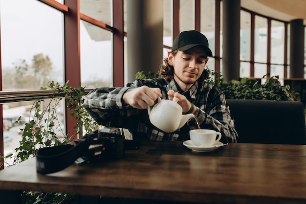 Fotograf Mann gießt Tee in eine Tasse