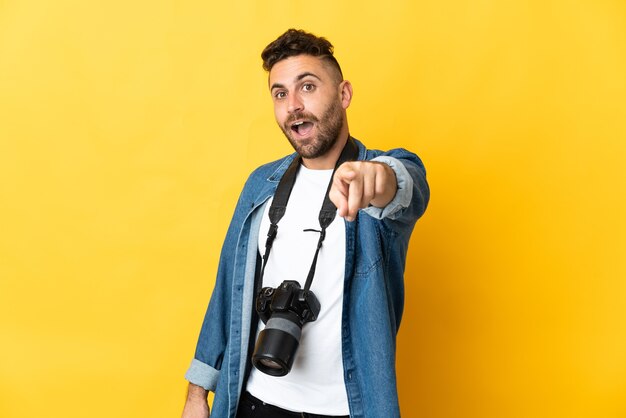 Fotograf Mann isoliert auf gelb überrascht und nach vorne zeigend