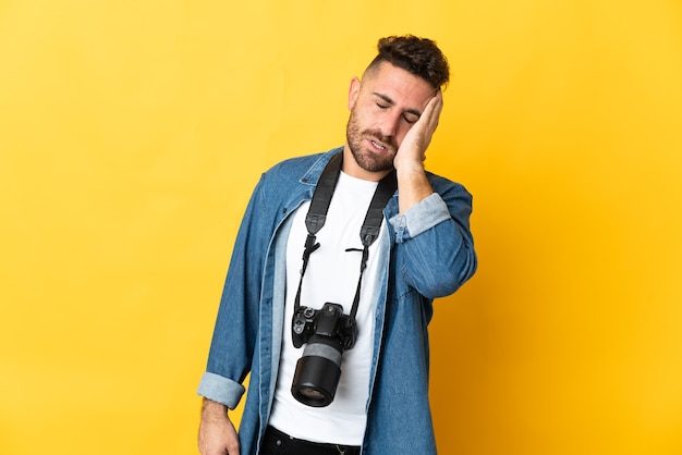 Fotograf Mann lokalisiert auf gelber Wand mit Kopfschmerzen