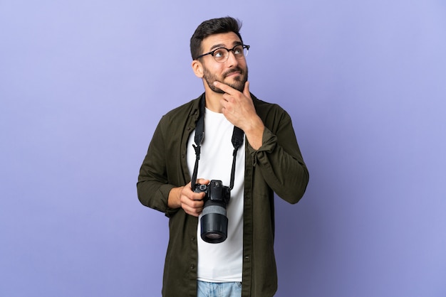 Fotograf Mann über isolierte lila Wand, die eine Idee beim Nachschlagen denkt