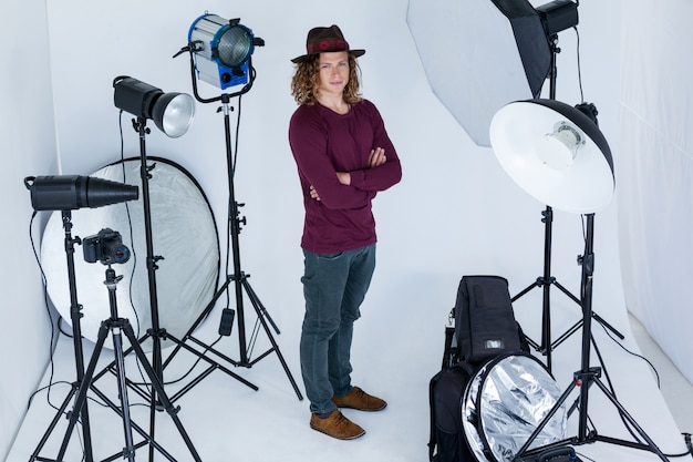 Fotograf mit gekreuzten Händen stehend im Fotostudio