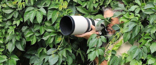 Fotograf versteckt sich in den Blättern