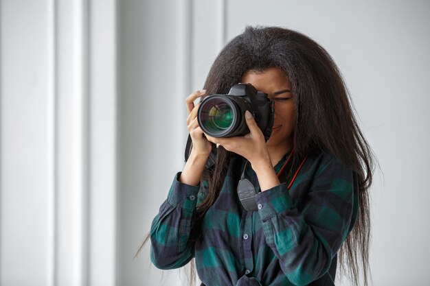 Foto una fotógrafa afroamericana con una cámara sesión de fotos en el estudio