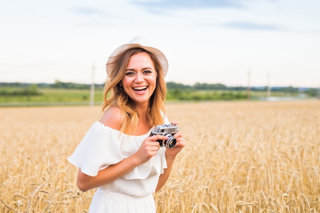 Fotógrafa en el campo con una cámara tomando fotografías.