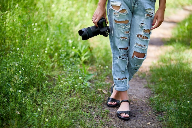 Fotógrafa com uma câmera fotográfica na mão ao ar livre