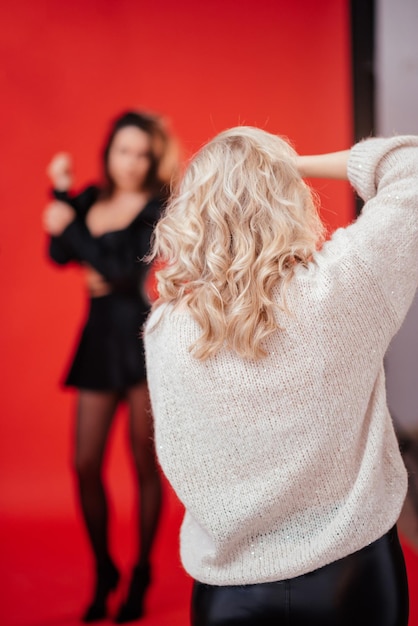 Fotógrafa fofa tirando fotos da modelo no estúdio fotográfico