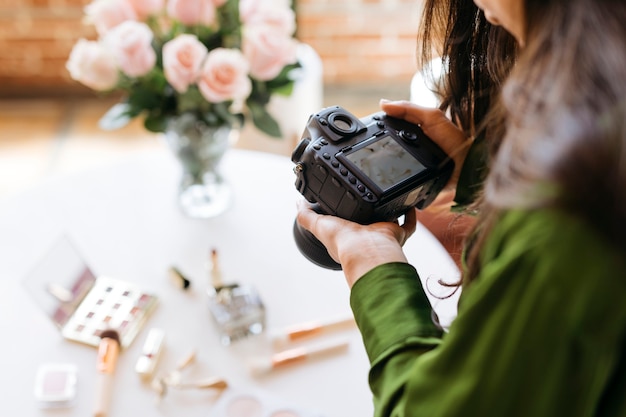 Fotógrafa fotografando produtos de beleza na mesa