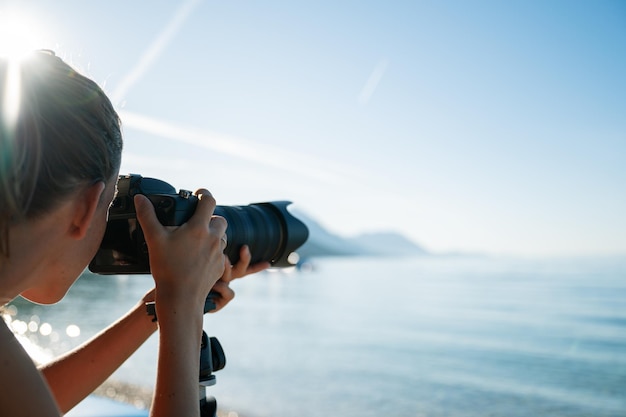 Fotógrafa profesional tomando fotos del hermoso mar matutino