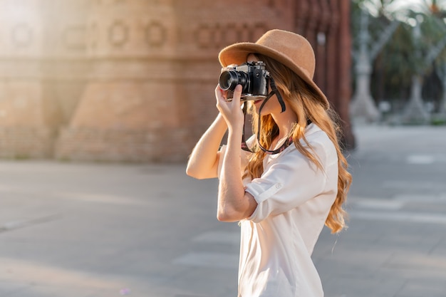 Fotógrafa profissional trabalhando nas ruas de Barcelona com uma câmera de filme vintage.