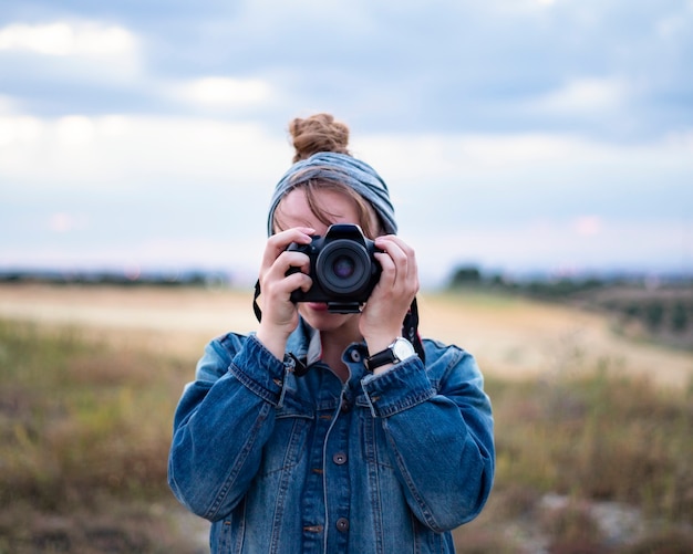 Fotógrafa, tirando uma foto em close da natureza,